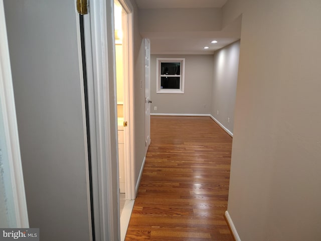 corridor featuring recessed lighting, baseboards, and wood finished floors