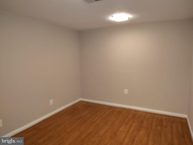 spare room with wood finished floors and baseboards