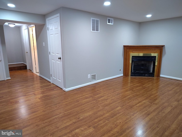 unfurnished living room featuring visible vents, recessed lighting, baseboards, and wood finished floors