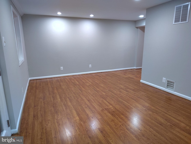 below grade area with visible vents and wood finished floors