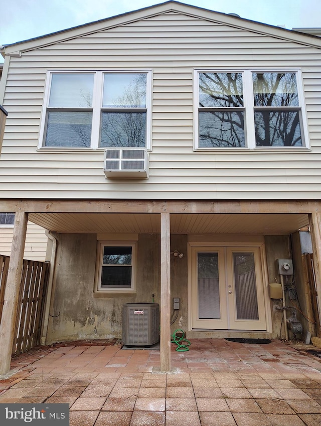 view of front of house with central air condition unit, a patio, and fence