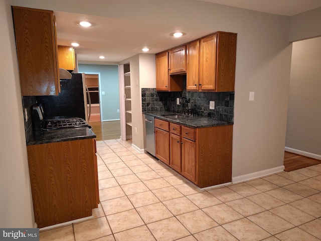 kitchen with backsplash, stainless steel dishwasher, range with gas cooktop, and a sink