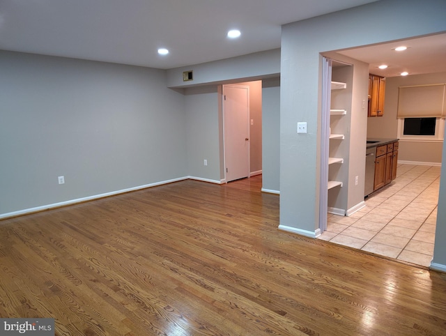 finished basement featuring light wood finished floors, recessed lighting, and baseboards