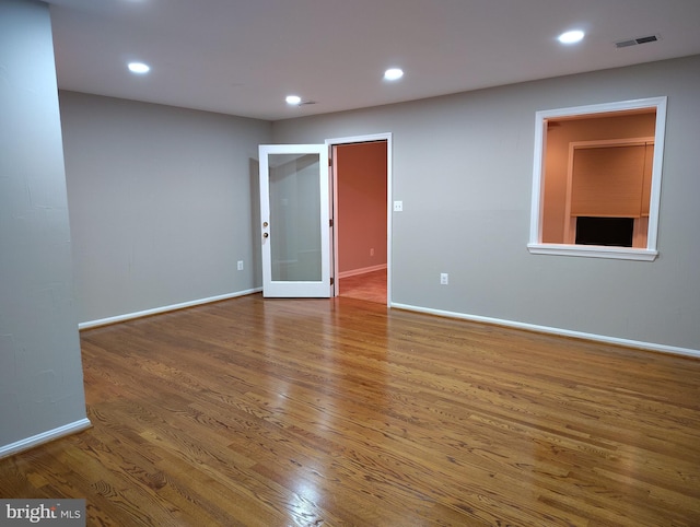 empty room with recessed lighting, wood finished floors, and baseboards