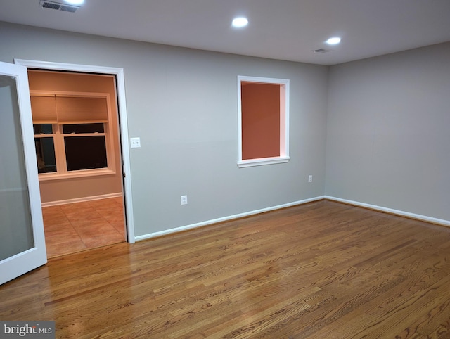 spare room with visible vents, recessed lighting, baseboards, and wood finished floors