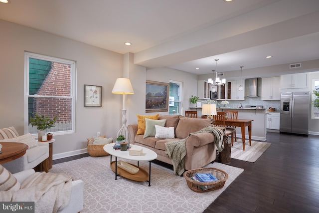 living room with a chandelier, dark wood-type flooring, baseboards, and recessed lighting