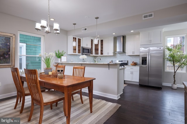 dining space with a chandelier, dark wood-style flooring, recessed lighting, and baseboards