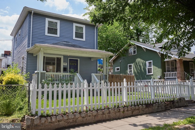 view of front of home featuring covered porch and a fenced front yard