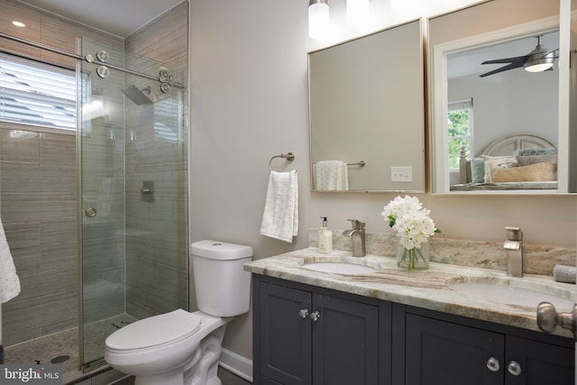 full bathroom with a stall shower, toilet, double vanity, and a ceiling fan