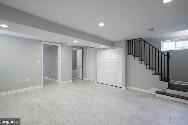 basement featuring recessed lighting, baseboards, wood finished floors, and stairs
