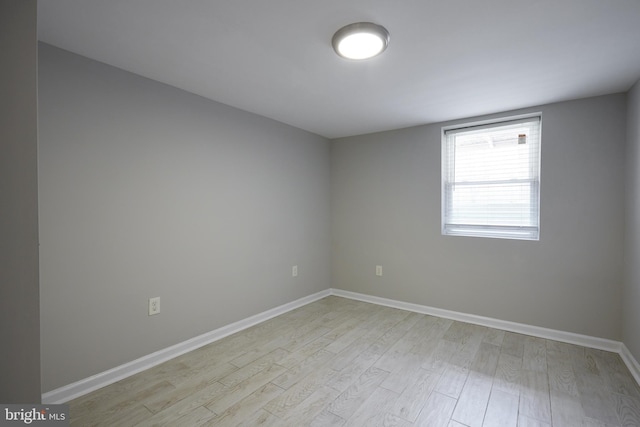 spare room featuring light wood finished floors and baseboards