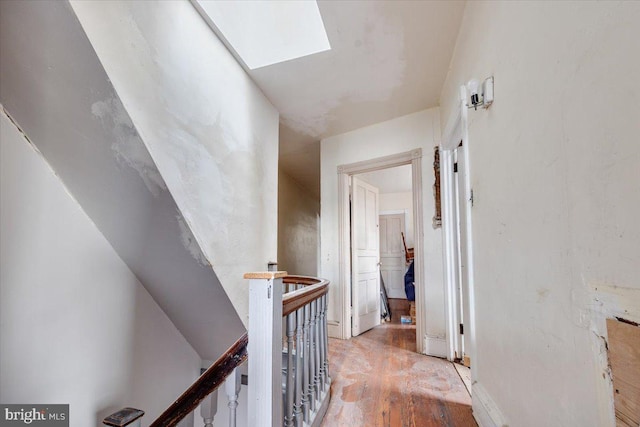 hall featuring a skylight and light hardwood / wood-style floors