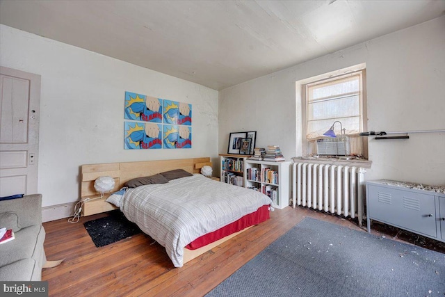 bedroom featuring radiator heating unit and dark hardwood / wood-style floors