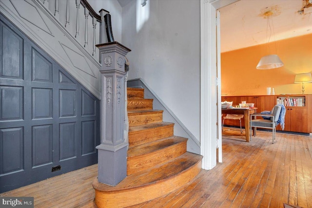 stairway featuring wood-type flooring and wooden walls