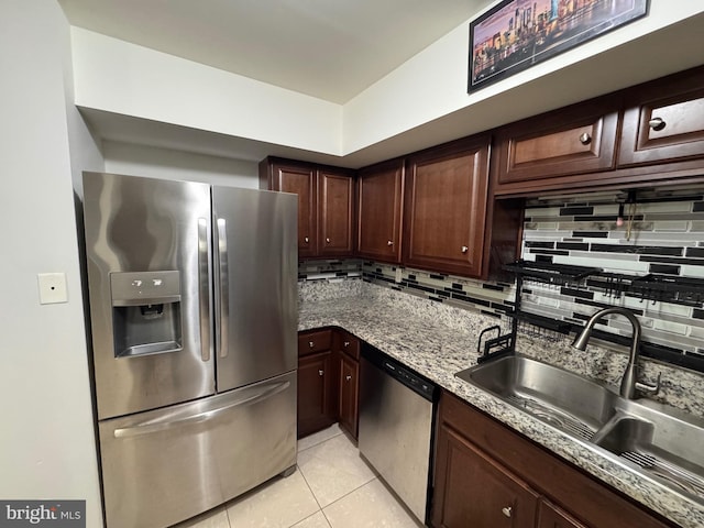 kitchen with light tile patterned floors, appliances with stainless steel finishes, sink, and backsplash