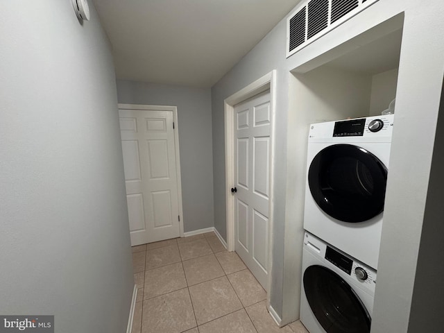 laundry area featuring light tile patterned flooring and stacked washer and dryer