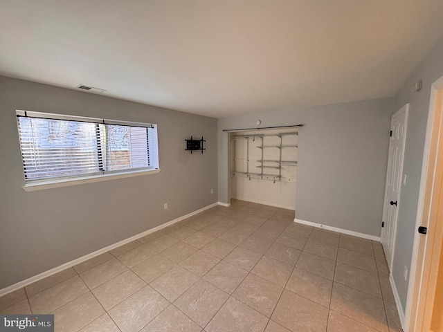 unfurnished bedroom featuring light tile patterned flooring and a closet