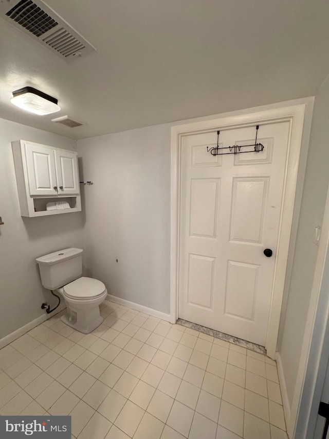 bathroom featuring toilet and tile patterned flooring