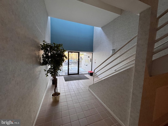 foyer entrance with a high ceiling and tile patterned flooring