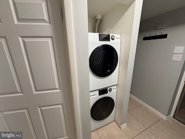 washroom featuring stacked washer / dryer and light tile patterned floors