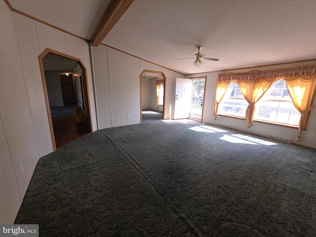 carpeted spare room with arched walkways, crown molding, a textured ceiling, and vaulted ceiling with beams