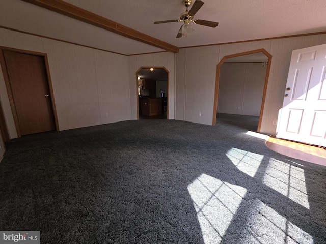 unfurnished living room featuring arched walkways, a ceiling fan, carpet, crown molding, and beam ceiling