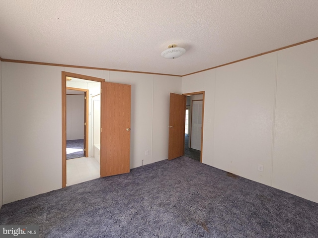 unfurnished bedroom featuring a textured ceiling, ornamental molding, and carpet