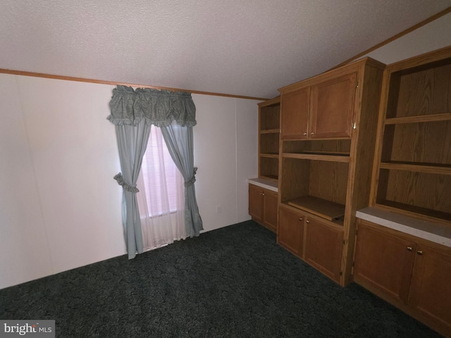 unfurnished room featuring dark colored carpet and a textured ceiling