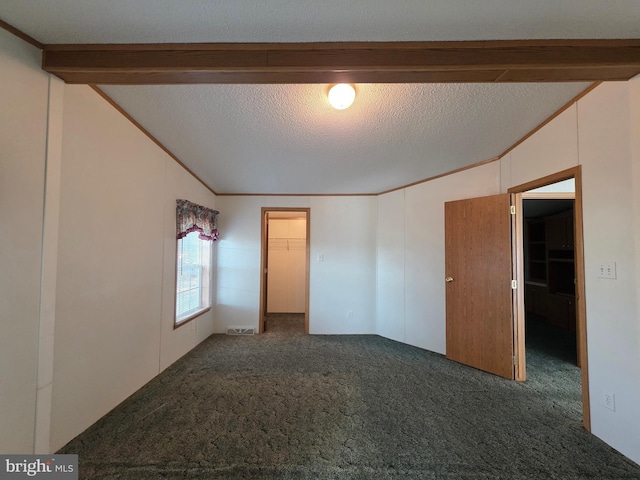 carpeted empty room featuring vaulted ceiling with beams, ornamental molding, and a textured ceiling