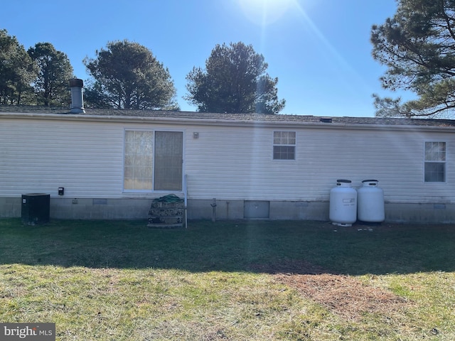 back of property featuring crawl space, cooling unit, and a lawn