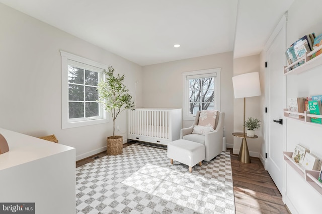 bedroom with a crib and light hardwood / wood-style floors