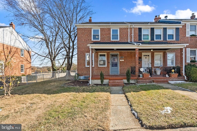 townhome / multi-family property with covered porch and a front lawn