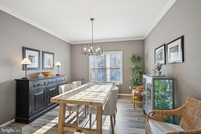 dining area featuring crown molding, hardwood / wood-style floors, and a chandelier