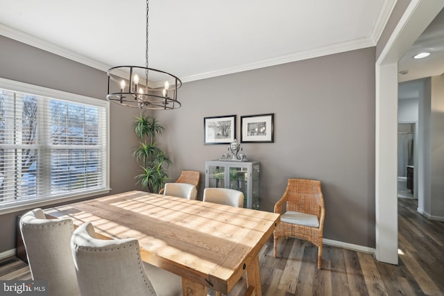 dining area with an inviting chandelier, crown molding, and dark hardwood / wood-style flooring