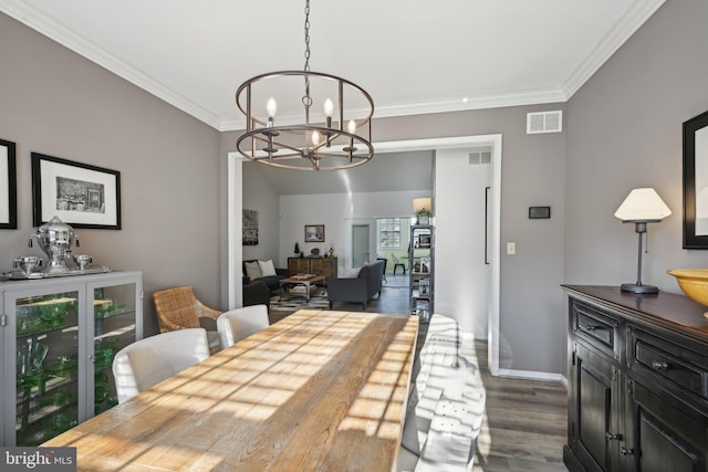 dining area with an inviting chandelier, ornamental molding, and hardwood / wood-style floors