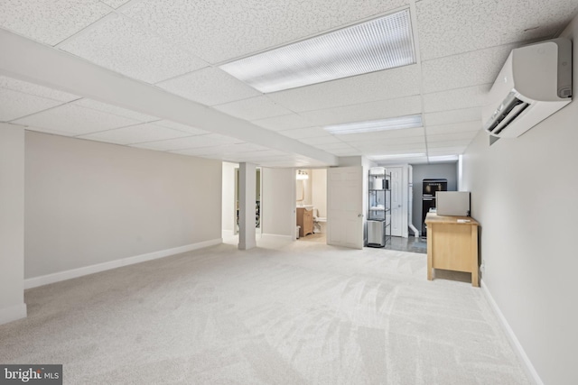 basement with a paneled ceiling, a wall mounted air conditioner, and light carpet