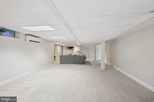 basement featuring light carpet, a paneled ceiling, and a wall unit AC