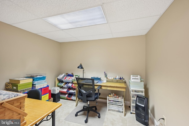 office space with carpet floors, heating unit, and a drop ceiling