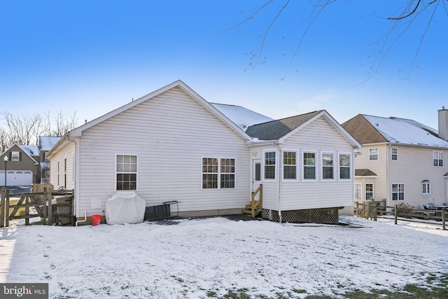 view of snow covered rear of property