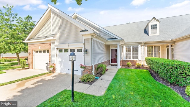 view of front of property with a garage, driveway, brick siding, and a front yard