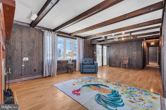 interior space with beam ceiling, light hardwood / wood-style flooring, and wood walls