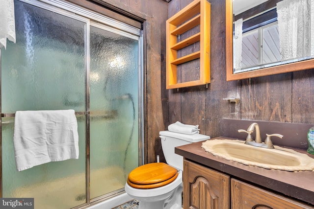 bathroom with an enclosed shower, vanity, toilet, and wood walls