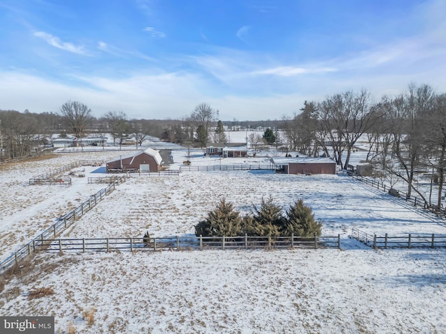 yard covered in snow with a rural view