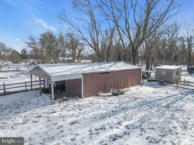 yard covered in snow featuring an outbuilding