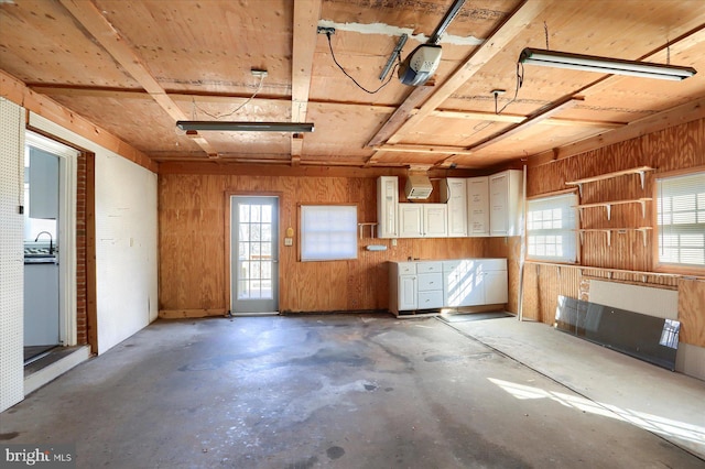 miscellaneous room with wooden walls and concrete floors