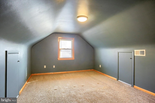 bonus room featuring vaulted ceiling and carpet