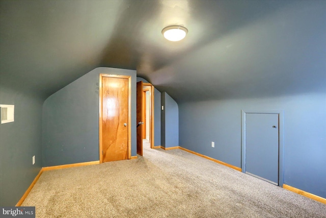 additional living space with vaulted ceiling and carpet flooring