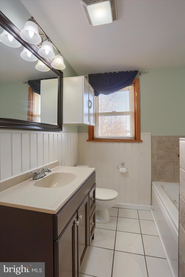 bathroom featuring vanity, toilet, and a bathing tub