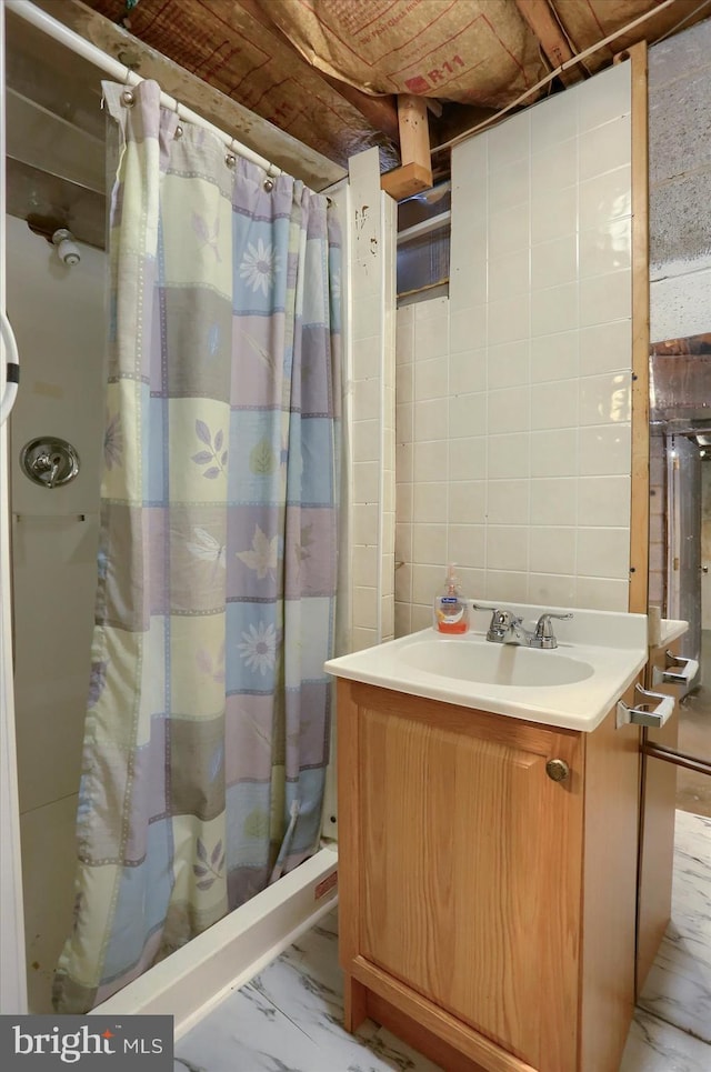 bathroom with tile walls, sink, and walk in shower