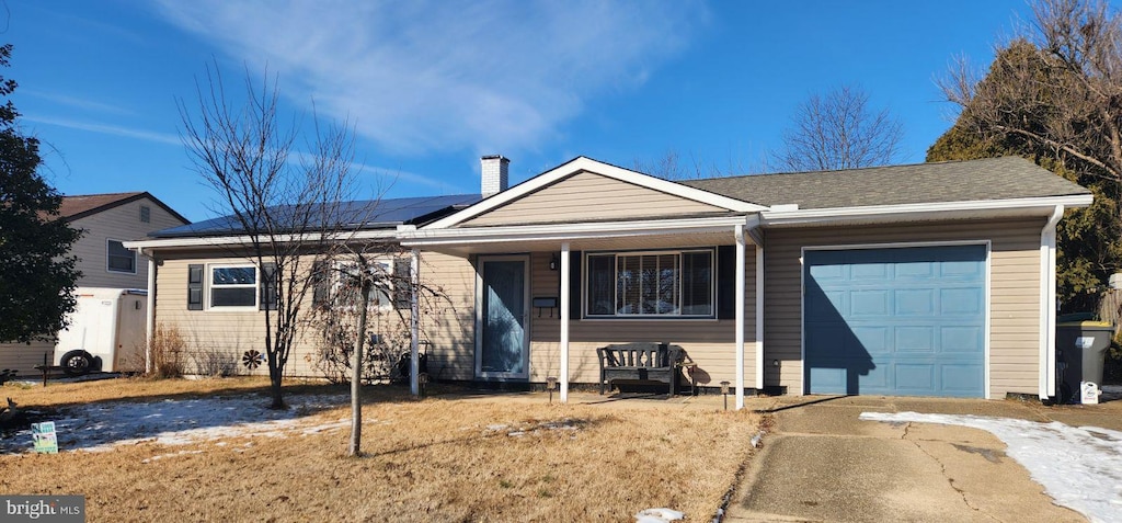 view of front facade featuring a garage and solar panels